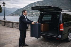 Autista professionale NCC aiuta i passeggeri con i bagagli per il transfer sul Lago di Como