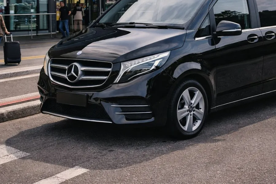 Minivan Mercedes nero davanti all'ingresso di un terminal aeroportuale
