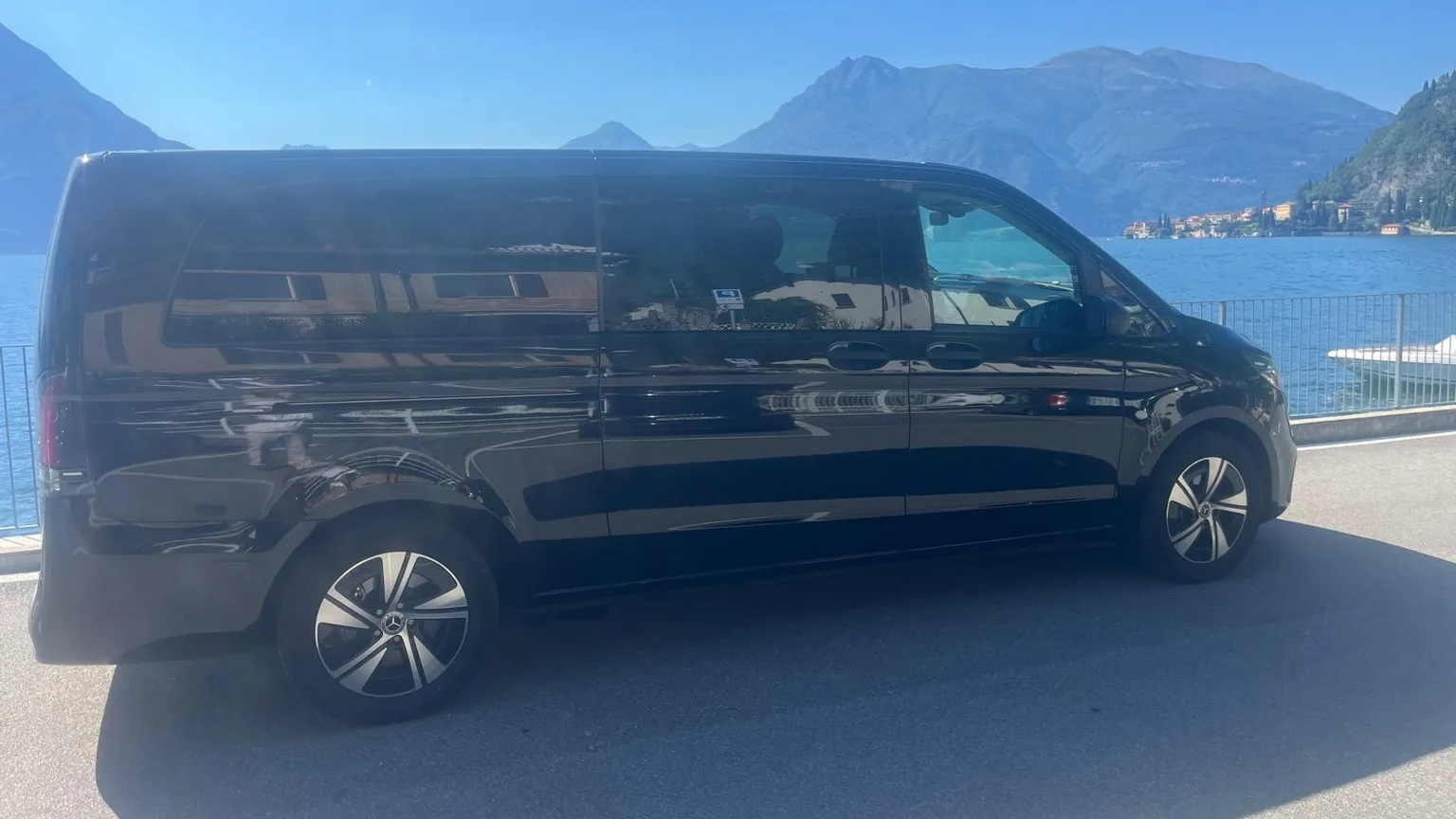 Valtellina private transfer: black Mercedes minivan parked by Lake Como